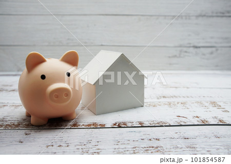 Piggy bank and house model on wooden background,Business investment and real estate concept Piggy bank and house model on wooden background,Business investment and real estate concept 101854587
