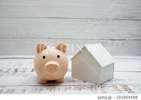 Piggy bank and house model on wooden background,Business investment and real estate concept Piggy bank and house model on wooden background,Business investment and real estate concept 101854588