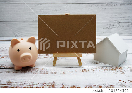 Piggy bank and house model on wooden background,Business investment and real estate concept Piggy bank and house model on wooden background,Business investment and real estate concept 101854590