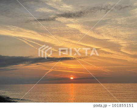 Stunning landscape of deep sunset over calm smooth sea with vibrant colors Stunning landscape of deep sunset over calm smooth sea with vibrant colors 101855151