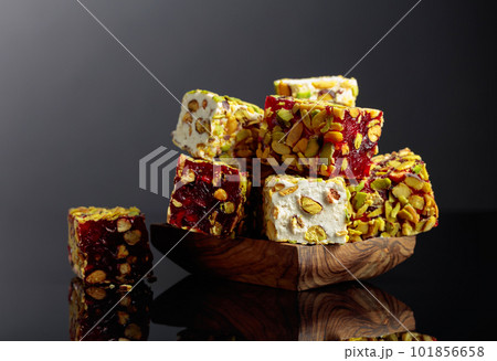 Turkish delight in a wooden dish on a black reflective background. Turkish delight in a wooden dish on a black reflective background. 101856658