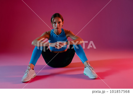 Fitness woman model in fashion sports wear relaxing on studio background Fitness woman model in fashion sports wear relaxing on studio background 101857568
