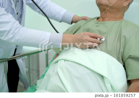 Elder Asian man sitting on the bed and talking to doctor about his physical injuries at his knees, elderly Asian man having a consulting with professional physical therapist or orthopedic doctor. Elder Asian man sitting on the bed and talking to doctor about his physical injuries at his knees, elderly Asian man having a consulting with professional physical therapist or orthopedic doctor. 101859257