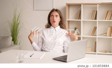 Hot day. Working woman. Heat suffer. Elegant lady in white shirt sitting office desk blowing herself with hands light room interior. Hot day. Working woman. Heat suffer. Elegant lady in white shirt sitting office desk blowing herself with hands light room interior. 101859884