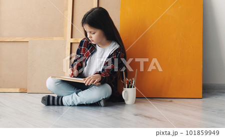 Painting time. Kids creativity. Inspired hobby. Little girl sitting floor drawing on paper in light room interior. 101859949