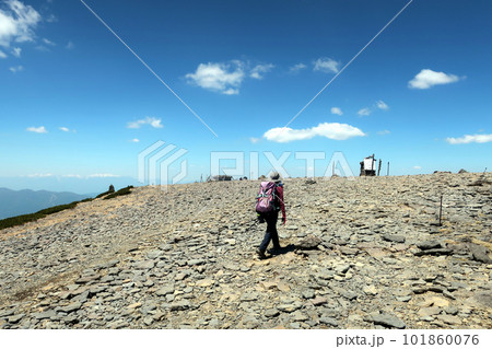 八ヶ岳の硫黄岳山頂を歩く女性登山者 101860076