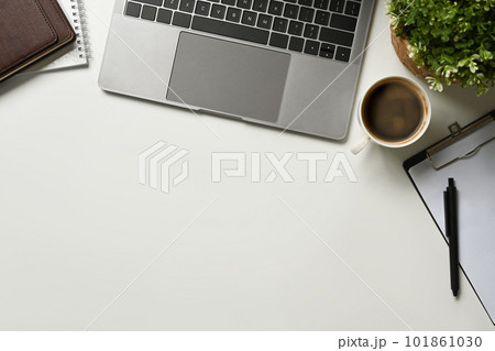 Modern white office desk table with laptop computer, cup of coffee and notebook. Top view with copy space, flat lay. Modern white office desk table with laptop computer, cup of coffee and notebook. Top view with copy space, flat lay. 101861030