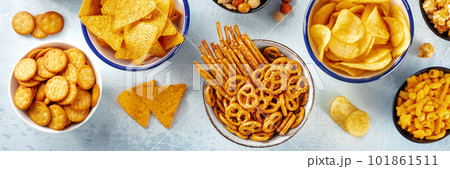 Salty snacks, party mix, top shot panorama. An assortment of crispy appetizers Salty snacks, party mix, top shot panorama. An assortment of crispy appetizers 101861511