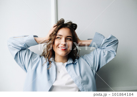 Image of attractive happy cheerful female student with curly hair and sincere smile enjoying weekend Image of attractive happy cheerful female student with curly hair and sincere smile enjoying weekend 101864184