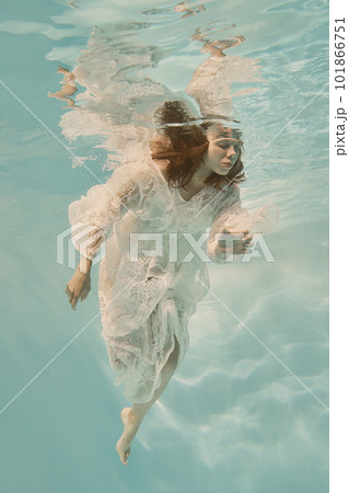 Portrait of a girl underwater in a white lace dress 101866751