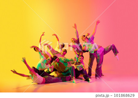Group of young people, girls dancing contemp against pink and yellow gradient background in neon light. Diversity, chaos and freedom. 101868629