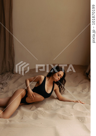 Attractive model posing in studio with sea sand. Attractive model posing in studio with sea sand. 101870199