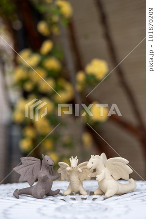 庭のテーブルの上に置いてある3匹のドラゴンの陶器の置物の写真