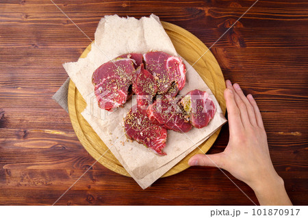 Raw Beef meat on old dark wooden table background, with spices, rosemary and sea salt. 101870917