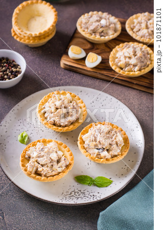 Tartlets filled with canned fish, eggs and mayonnaise on a plate vertical view Tartlets filled with canned fish, eggs and mayonnaise on a plate vertical view 101871101