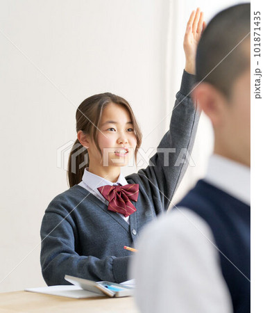 手を挙げる授業中の女子中学生 101871435