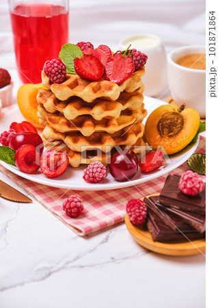 Belgian waffles with strawberries, apricots, cherries, juice and a cup of black coffee 101871864
