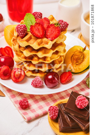 Belgian waffles with strawberries, apricots, cherries, juice and a cup of black coffee 101871868