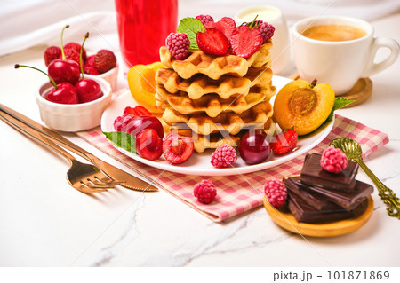 Belgian waffles with strawberries, apricots, cherries, juice and a cup of black coffee 101871869