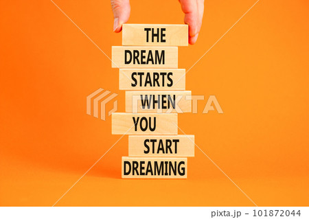 Start dreaming symbol. Concept words The dream starts when you start dreaming on wooden blocks. Beautiful orange background. Copy space. Businessman hand. Motivational business start dreaming concept. Start dreaming symbol. Concept words The dream starts when you start dreaming on wooden blocks. Beautiful orange background. Copy space. Businessman hand. Motivational business start dreaming concept. 101872044