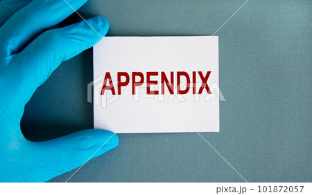 Hand in blue glove with white card. Concept word 'appendix'. Medical concept. Copy space. 101872057