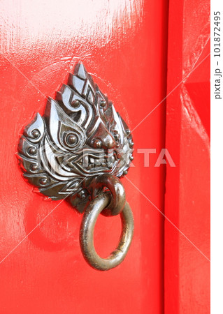 Close up red door - Freshly painted red front door with mythical creature head bronze knocker Close up red door - Freshly painted red front door with mythical creature head bronze knocker 101872495