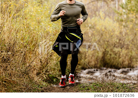 male runner running on autumn trail marathon, cross-country running race 101872636