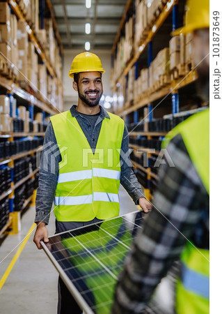 Smiling warehouse workers carring a solar panel. Smiling warehouse workers carring a solar panel. 101873649