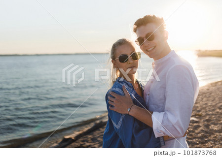 Young cupple cuddling during sunset at sea. Young cupple cuddling during sunset at sea. 101873768