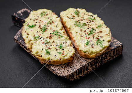 Grilled toast with avocado paste, eggs, cream cheese, salt, spices and herbs 101874667