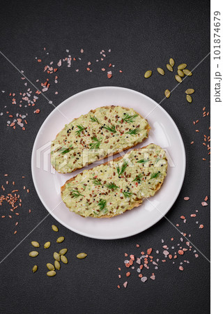 Grilled toast with avocado paste, eggs, cream cheese, salt, spices and herbs 101874679