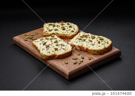 Grilled toast with avocado paste, eggs, cream cheese, salt, spices and herbs 101874680