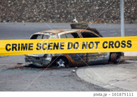 American police tape barricading a burnt car 101875111