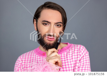 Beautiful transgender person model person applying powder on face preparing for photo session Beautiful transgender person model person applying powder on face preparing for photo session 101875156
