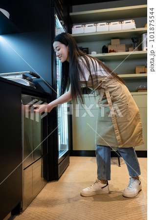 Asian cafe employee using the dishwashing machine in the workplace 101875544