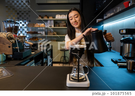 Concentrated young Asian barista brewing pour-over coffee 101875565
