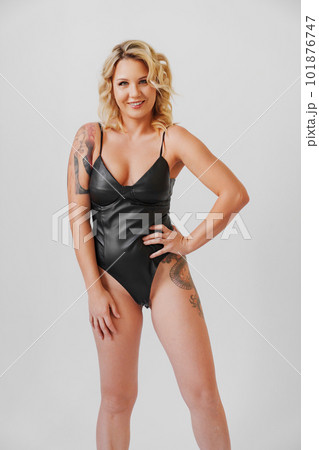 a sexy blonde with tattoos in a leather swimsuit 101876747
