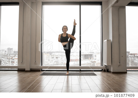 Female yogi performing variation of trivikramasana posture 101877409