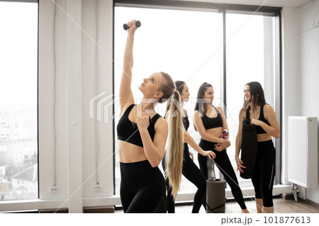 Female friends relaxing after exercises in yoga studio Female friends relaxing after exercises in yoga studio 101877613