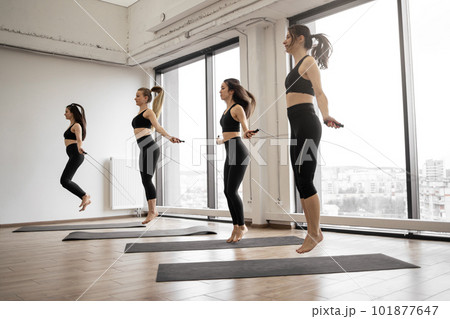 Females jumping with skipping rope in fitness studio 101877647