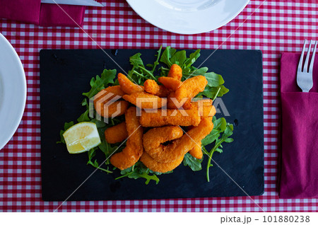 Traditional Spanish beer snack - sepia fried in bread crumbs, served with arugula Traditional Spanish beer snack - sepia fried in bread crumbs, served with arugula 101880238