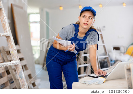 Woman worker checking documents and using laptop in construction site Woman worker checking documents and using laptop in construction site 101880509
