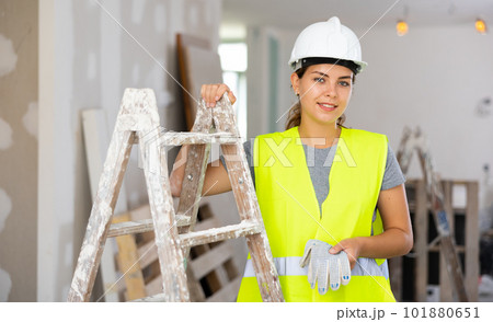 Portrait of positive woman builder during repair works 101880651