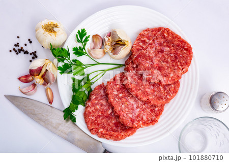Cooking ingredients, raw burger cutlets on board Cooking ingredients, raw burger cutlets on board 101880710