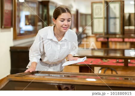 Young girl in the museum looks at the exposition behind glass case 101880915
