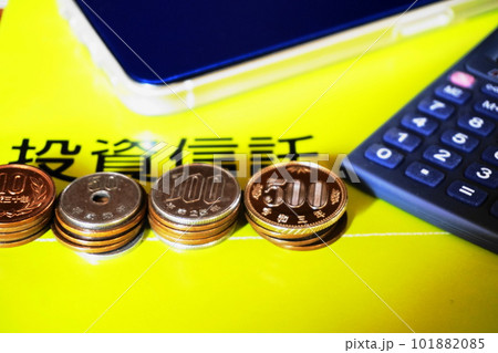 並べられた各種硬貨と電卓、スマートフォン、投資信託イメージ 並べられた各種硬貨と電卓、スマートフォン、投資信託イメージ 101882085
