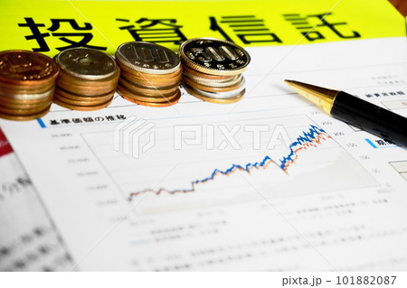 資料の上に並べられた各種硬貨とペン、投資信託イメージ 資料の上に並べられた各種硬貨とペン、投資信託イメージ 101882087