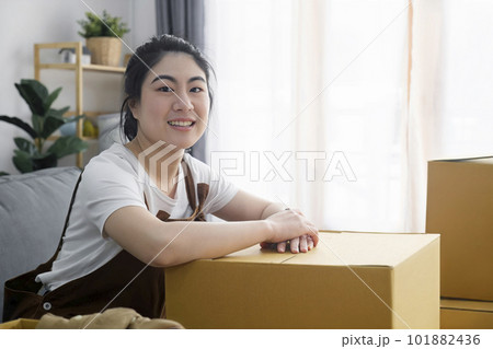 Happy woman smiling at home during move with boxes Happy woman smiling at home during move with boxes 101882436