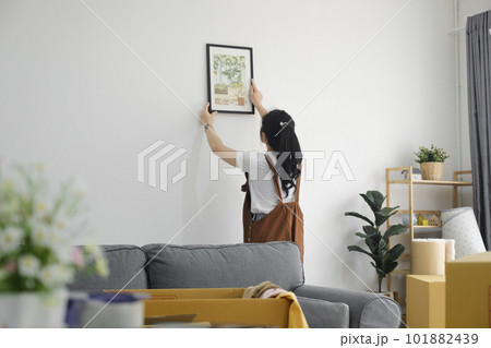 Woman decorating new home while moving in to new house or apartment. Woman decorating new home while moving in to new house or apartment. 101882439