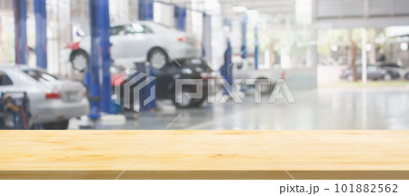 Empty wood table top with car service centre auto repair workshop blurred background Empty wood table top with car service centre auto repair workshop blurred background 101882562